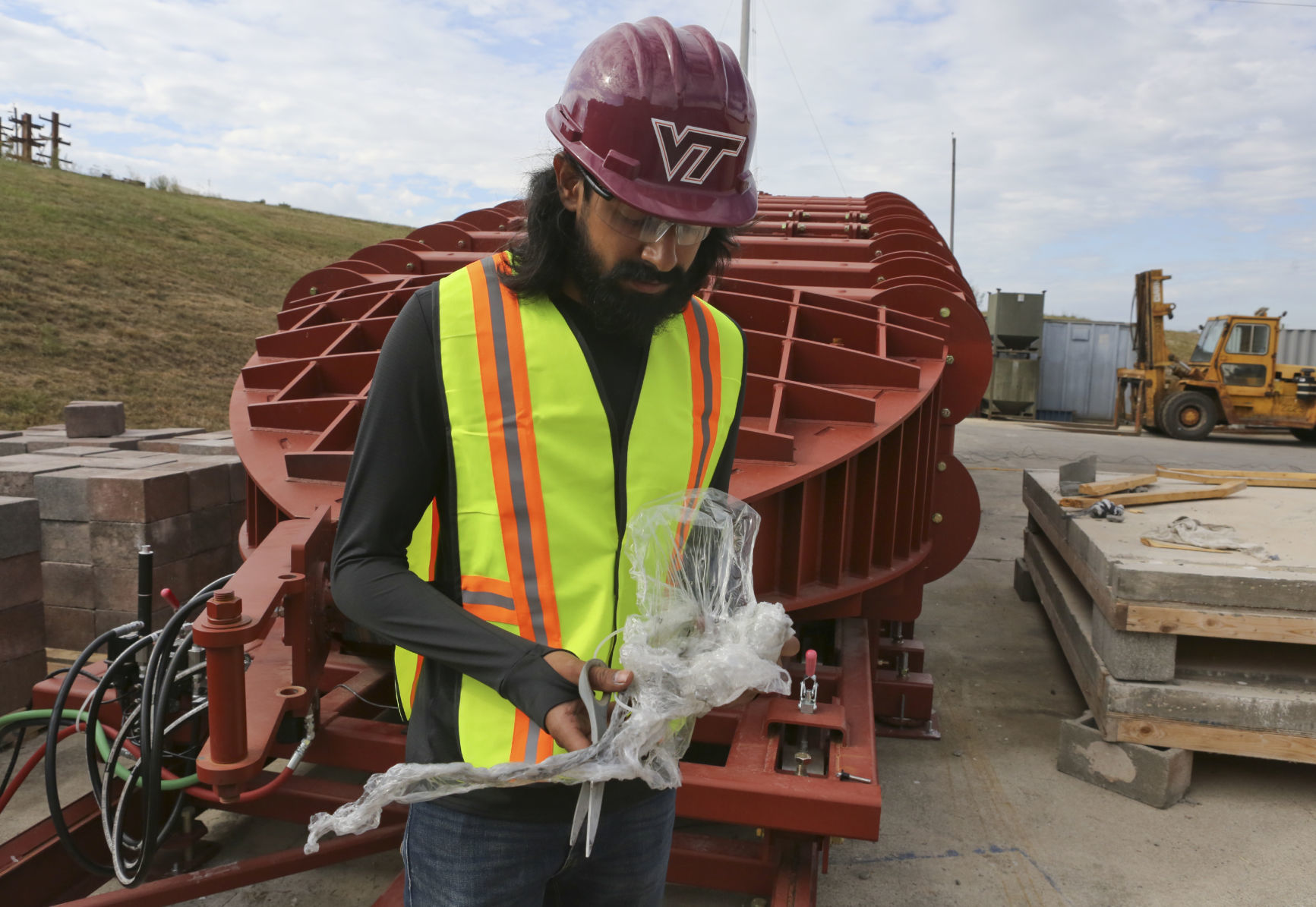A graduate student holds a part of the tube’s firing mechanism